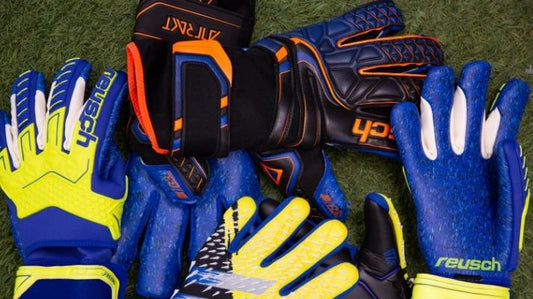 different soccer goalie gloves on grass