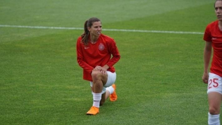 Woman soccer player stretching on soccer field