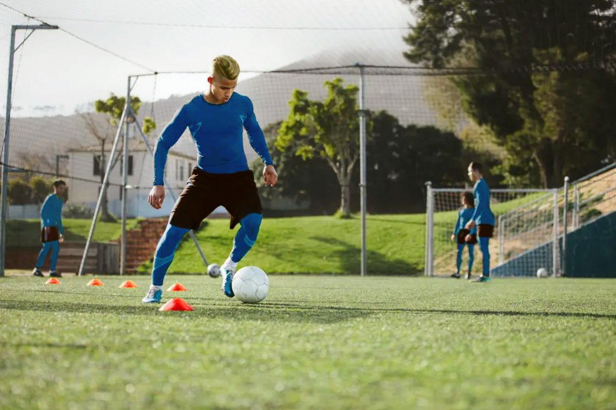 Soccer player dribbling through cones